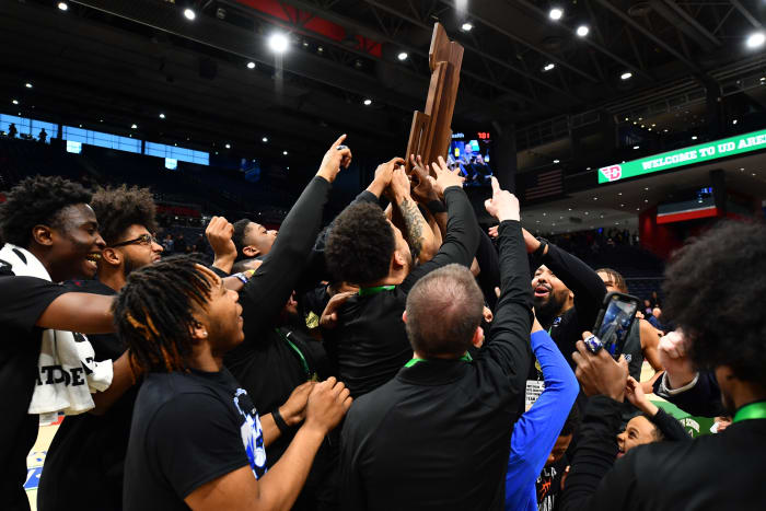 Lutheran East players and coaches hoist the OHSAA Division III state championship trophy.